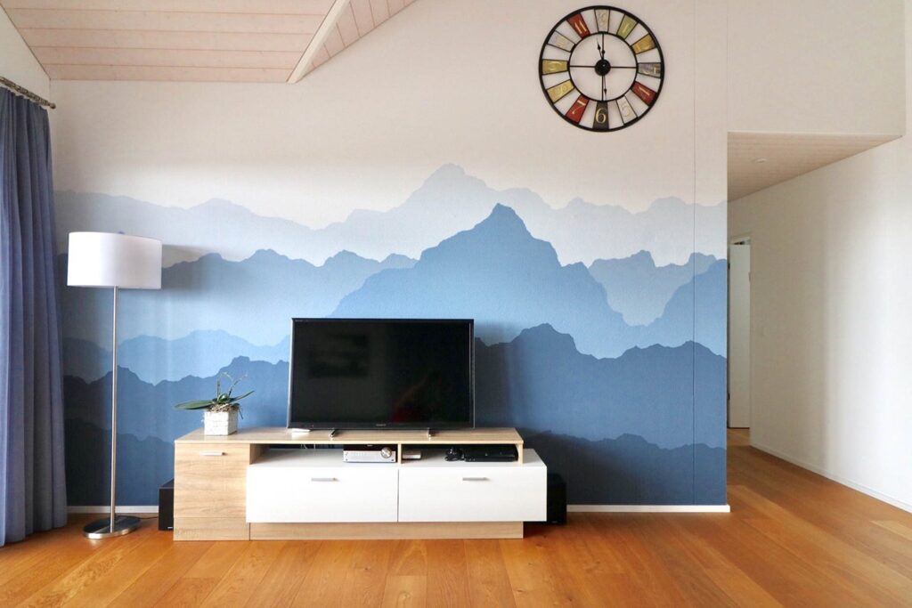 Wohnzimmer mit blau gemaltem Bergpanorama an der Wand