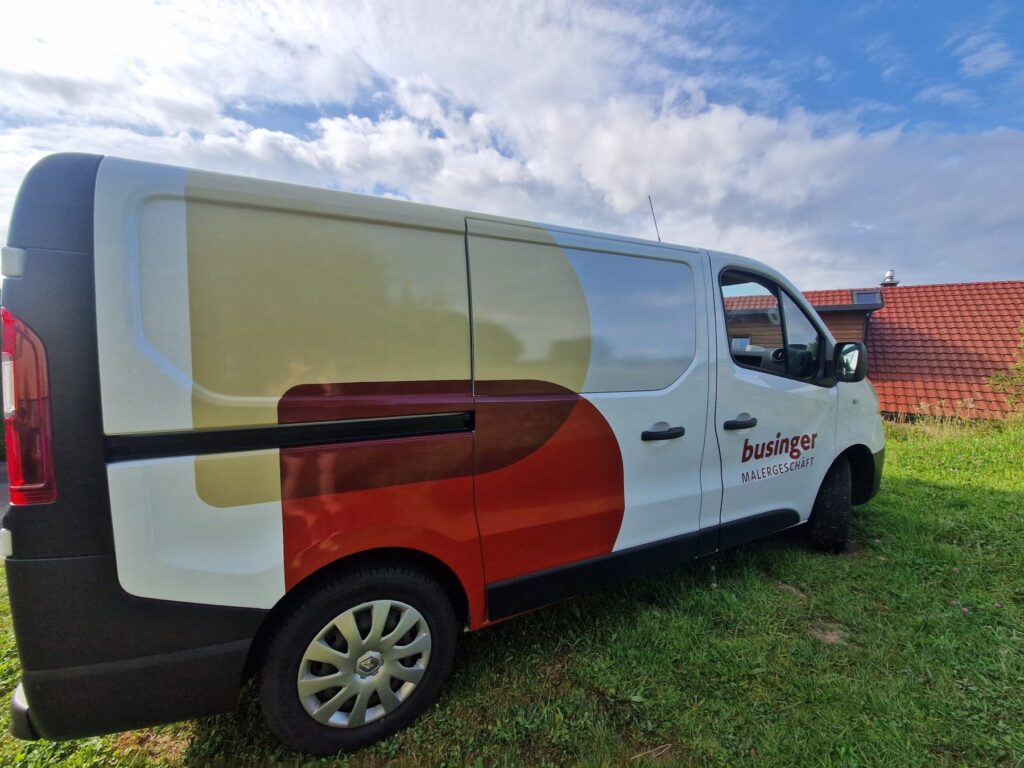 Weisser Lieferwagen mit der Beschriftung Businger Malergeschäft und farbigen Kreisflächen