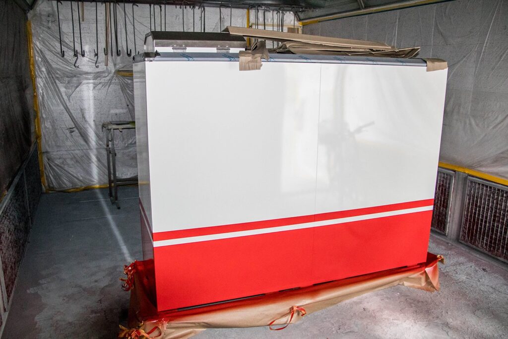 Grosser Metallkorpus in Weiss und Rot, abgeklebt in der Spritzkabine